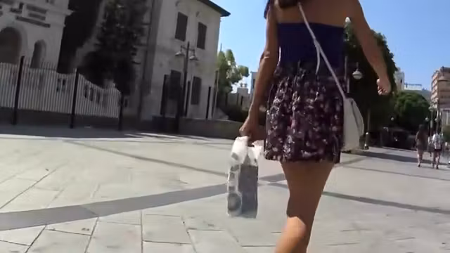 Cute girl protects her skirt from wind