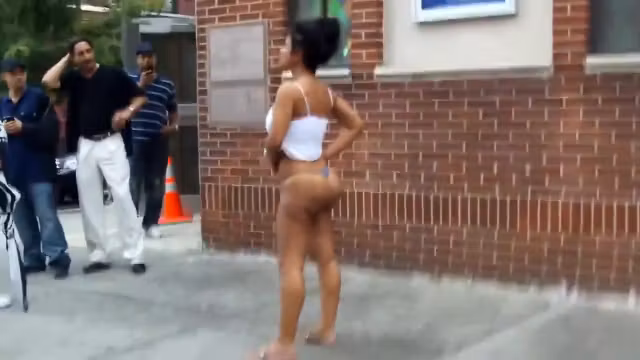 Crazy madam with a massive behind stands on the middle of the sidewalk