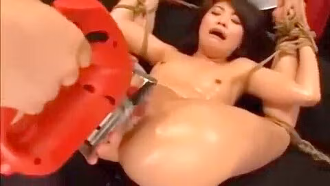 Her hands and feet are restrained and a machine vibrator is inserted and removed repeatedly.