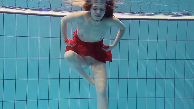 Red Dressed teen swimming with her eyes opened